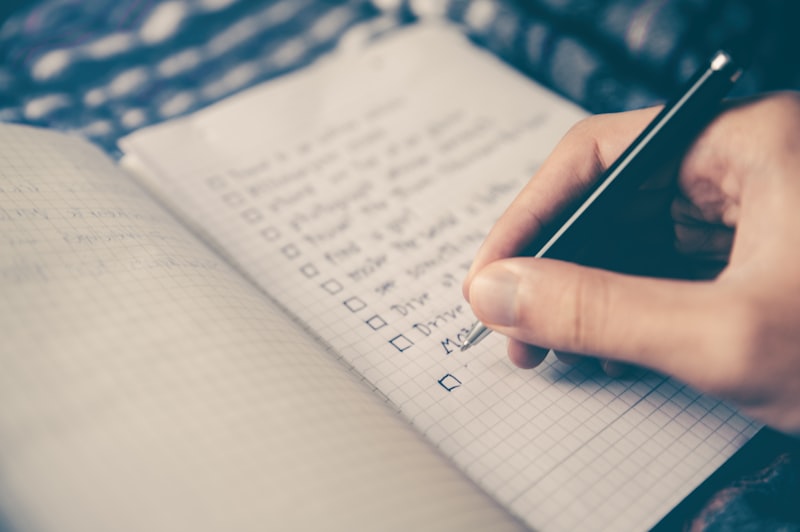 A high-quality, professional, minimalist image of a sleek smartphone on a wooden desk showing a clean habit tracking application with colorful checkmarks. No people, no women. Modern and premium feel.